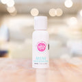 Mini Shower Oil bottle with citrus and floral scent on wooden surface