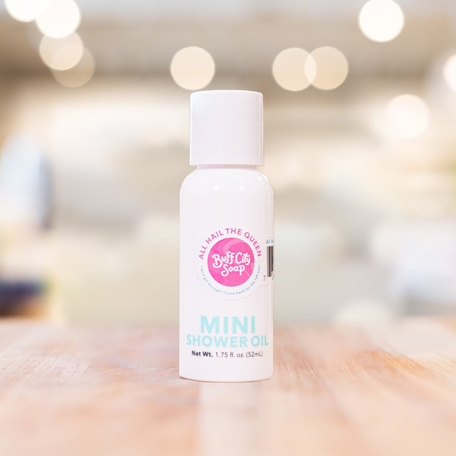 Mini Shower Oil bottle with citrus and floral scent on wooden surface